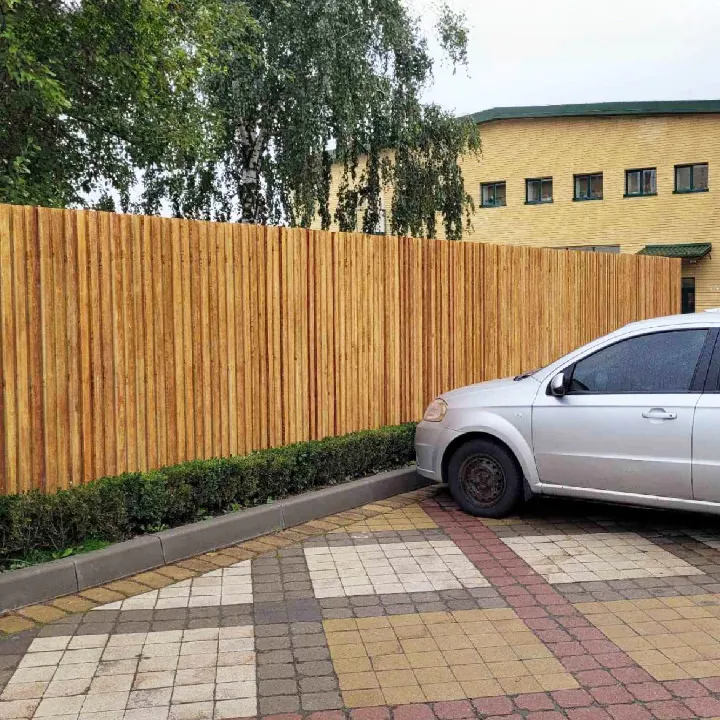 Огорожа, облицьована бетонною рейкою, та вимощений двір